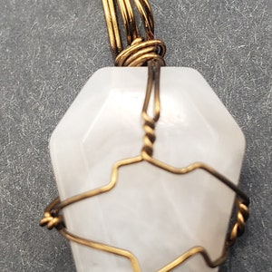 Collier avec pierre en forme de cercueil de quartz blanc enveloppé de fil de bronze