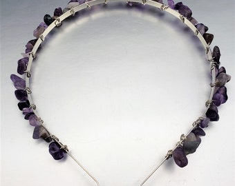 Könnte beinhalten: Ein silberfarbenes Metall-Haarband, verziert mit unregelmäßig geformten, lila Amethyststeinen. Die Steine sind mit silbernem Draht befestigt, was ein einzigartiges und elegantes Haaraccessoire ergibt.