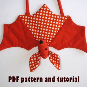 Puede incluir: Murciélago de tela roja con lunares blancos, ojos negros y un lazo para colgar. Patrón PDF y tutorial.