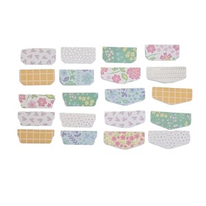 May include: A collection of twenty-one decorative paper tags in various floral and patterned designs. The tags feature a variety of colors, including pink, yellow, green, and blue, with patterns such as hearts, dots, and floral prints.
