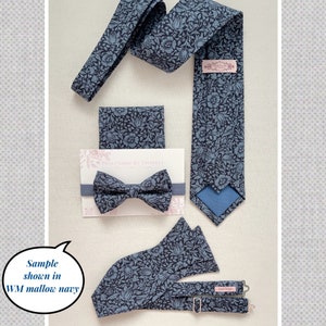 May include: A navy blue necktie, a pre-tied bow tie on a display card, a pocket square, and adjustable suspenders, all featuring a repeating floral pattern. The necktie includes a pink label reading PinkPeony by Christy. Text on the image includes Sample shown in WM mallow navy.