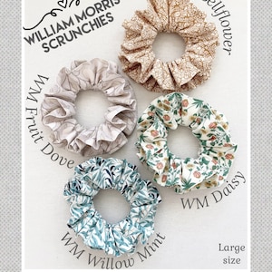 May include: Four large scrunchies in different floral patterns. The scrunchies are labeled "WM Fruit Dove", "WM Bellflower", "WM Daisy", and "WM Willow Mint". The text "William Morris Scrunchies" is at the top of the image. The text "Large size" is at the bottom of the image.