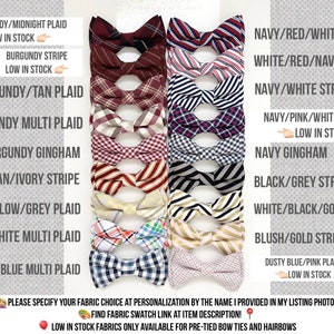 May include: A collection of 16 bow ties in various colors and patterns, including burgundy, navy, white, tan, pink, grey, yellow, and black. The bow ties are arranged in two rows of eight, with the names of each pattern listed below each bow tie. Some of the bow ties are marked as "low in stock".