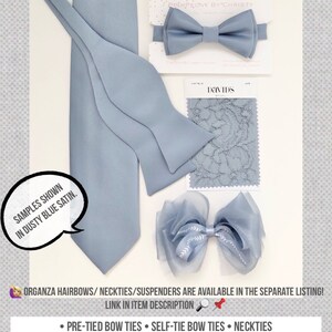 May include: A selection of dusty blue satin bow ties, a bow tie in dusty blue satin, a dusty blue satin pocket square, and a dusty blue organza hair bow. The text "PinkPeony by Christy" is visible in the image.