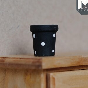 May include: Black and white polka dot planter, a miniature ceramic pot for dollhouses or miniature gardens.