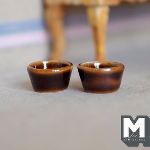 May include: Two small brown ceramic bowls, perfect for miniature dollhouse decor.