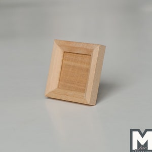 May include: A small, wooden picture frame with a natural wood finish. The frame is empty and ready for a photo or artwork.