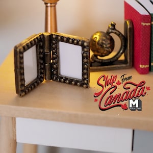 May include: A miniature wooden table with a white drawer, a small gold picture frame, and a set of bookends with a globe design. The bookends are holding three miniature books, one red, one green, and one blue.