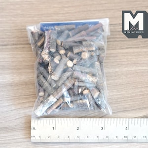 May include: A clear plastic bag filled with small, brown twigs, measuring approximately 5 inches in length. The bag is labeled "M for Miniatures".