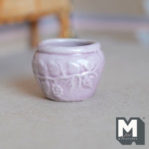 Op de afbeelding: Een kleine, lichtpaarse keramische pot met een druivenrankenontwerp. De pot is perfect voor miniatuurplanten of vetplanten.