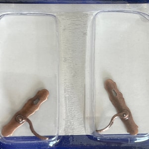 Könnte beinhalten: Zwei antike Kupfer-Türgriffe mit einem Schlüsselloch und einem Hebel. Die Griffe sind in einer durchsichtigen Plastikverpackung verpackt.