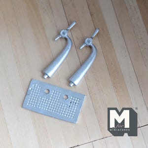 May include: Two silver metal beer taps with a silver metal bar top with a grid pattern. The bar top is labeled "M for Miniatures".