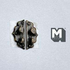May include: Two antique-style metal cabinet latches with a dark bronze finish. Each latch has a decorative, ornate design with a knob and a hook. The latches are on a white background.