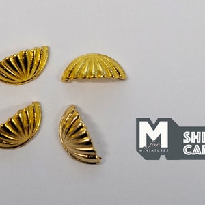 May include: Four gold-coloured metal half-dome shapes with a ribbed design. These decorative pieces are ideal for dollhouse or miniature projects.