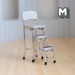 Può includere: Uno sgabello a tre gradini in metallo argentato. Il gradino superiore è una sedia con schienale. Lo sgabello è fatto per case di bambole in miniatura.