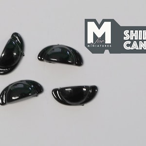 May include: Four black plastic half-round cabinet door pulls. The pulls are approximately 2.5 cm in diameter.
