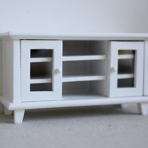 Pode incluir: Um arm&aacute;rio de madeira branco com duas portas de vidro e duas prateleiras. O arm&aacute;rio tem um design simples e &eacute; perfeito para guardar objetos em uma sala de estar ou um quarto.
