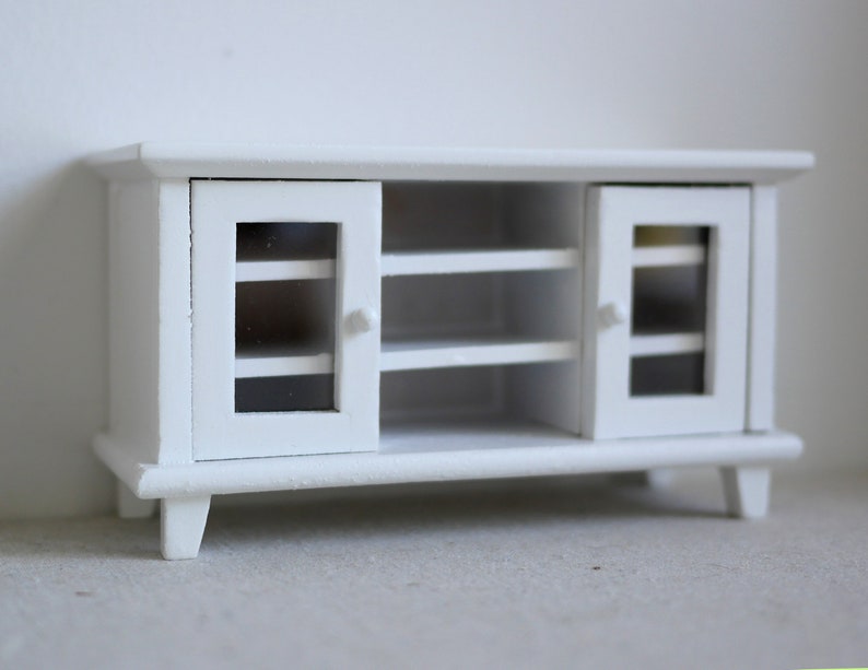 Pode incluir: Um arm&aacute;rio de madeira branco com duas portas de vidro e duas prateleiras. O arm&aacute;rio tem um design simples e &eacute; perfeito para guardar objetos em uma sala de estar ou um quarto.
