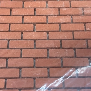 Puede incluir: Un muro de ladrillo con un patrón de ladrillo rojo. Los ladrillos están dispuestos en un patrón escalonado, con las juntas de mortero visibles.