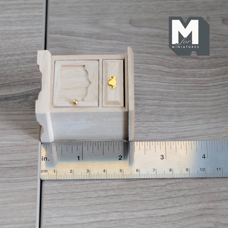Peut inclure: Un petit cabinet en bois miniature avec une seule porte et un tiroir. Le cabinet mesure 5 cm de large et est en bois brut.