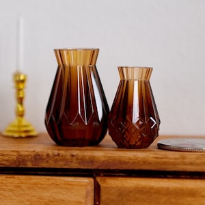 May include: Two brown glass vases with a diamond pattern. The larger vase is about 4 inches tall and the smaller vase is about 3 inches tall.