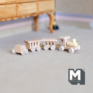 Pode incluir: Um conjunto de trem de madeira em miniatura com quatro vagões, incluindo uma locomotiva, um vagão de carga e dois vagões planos. O trem é feito de madeira não pintada e tem pequenas rodas pretas. O trem está sobre uma superfície de cor castanho claro.