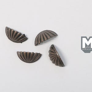 May include: Four small, semi-circular metal drawer pulls with a dark bronze finish and a ribbed, fan-like texture. Each piece features a curved edge and a flat mounting side. A grey logo with the text M for MINIATURES is visible on the right.