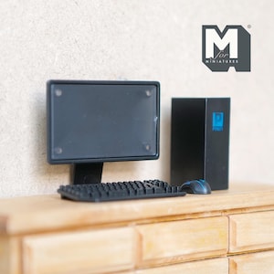 Op de afbeelding: Miniatuur zwarte computer set, inclusief een monitor, toetsenbord, muis en CPU-toren. De monitor en CPU-toren zijn zwart, en de muis is blauw en zwart. Het toetsenbord is zwart. Het logo "M for MINIATURES" staat rechtsboven.