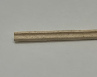 May include: A close-up of a wooden dowel rod with two grooves running along its length. The dowel is light brown in color and has a smooth, polished finish.