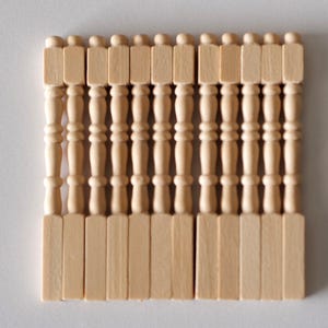 May include: A collection of small, unfinished wooden balusters, perfect for miniature projects. Each baluster features a turned design with a square top and base, and a rounded finial. The natural wood color offers versatility for painting or staining.