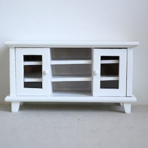 Pode incluir: Um arm&aacute;rio de madeira branco com duas portas de vidro e duas prateleiras. O arm&aacute;rio tem um design simples e &eacute; perfeito para guardar pequenos objetos.