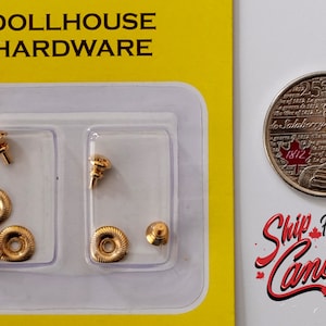 Op de afbeelding: Een pakket met goudkleurige poppenhuisbeslag. Het pakket bevat zes beslagdelen: twee knoppen, twee ronde grepen en twee kleine schroeven. Het pakket is gelabeld met "Dollhouse Hardware".
