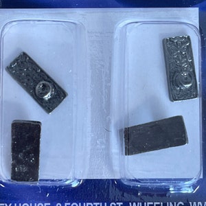 May include: Four silver-coloured metal key blanks in a clear plastic packaging. The key blanks are arranged in two rows of two.