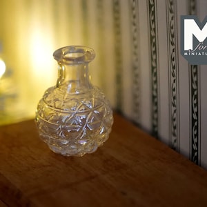 May include: A clear glass vase with a diamond pattern. The vase is sitting on a wooden surface.