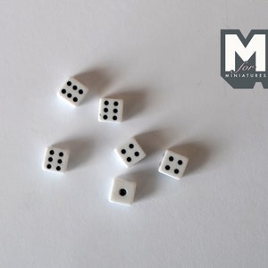 May include: Six white dice with black dots on a white surface. The dice are scattered randomly.