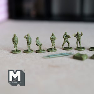 May include: A set of eight green plastic miniature soldiers, each with a different pose and weapon. The soldiers are standing on small round bases. The miniatures are part of a wargaming set.