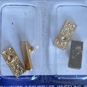 Könnte beinhalten: Vier goldfarbene Metall-Türbeschläge, darunter zwei Türknauf und zwei Türplatten, verpackt in einem durchsichtigen Kunststoffbehälter.