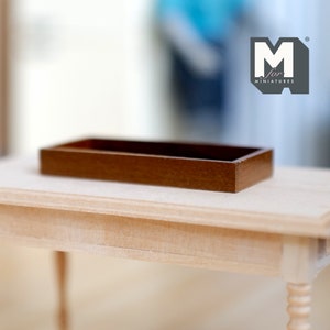 May include: A brown wooden tray, perfect for miniature dollhouse decor. The tray is made of wood and has a smooth finish. It is a great addition to any dollhouse kitchen or dining room.