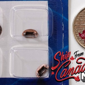 May include: Four antique-style copper-colored door handles in a clear plastic packaging. The handles are approximately the size of a Canadian 25-cent coin.