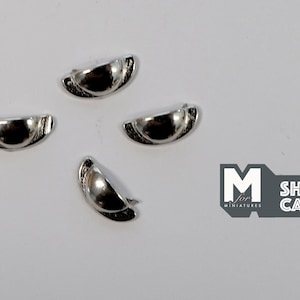 May include: Four silver-toned, half-round cabinet door pulls with a raised centre. The pulls are approximately 2.5 cm in diameter.