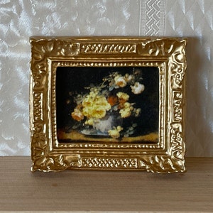 May include: A gold framed picture with a painting of a bouquet of yellow and orange flowers in a vase.