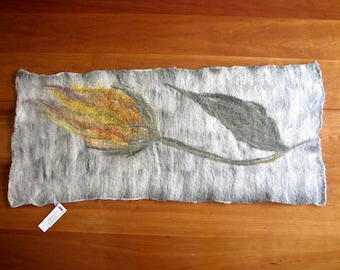 May include: A gray felt scarf with a yellow and brown flower and a dark gray leaf design.