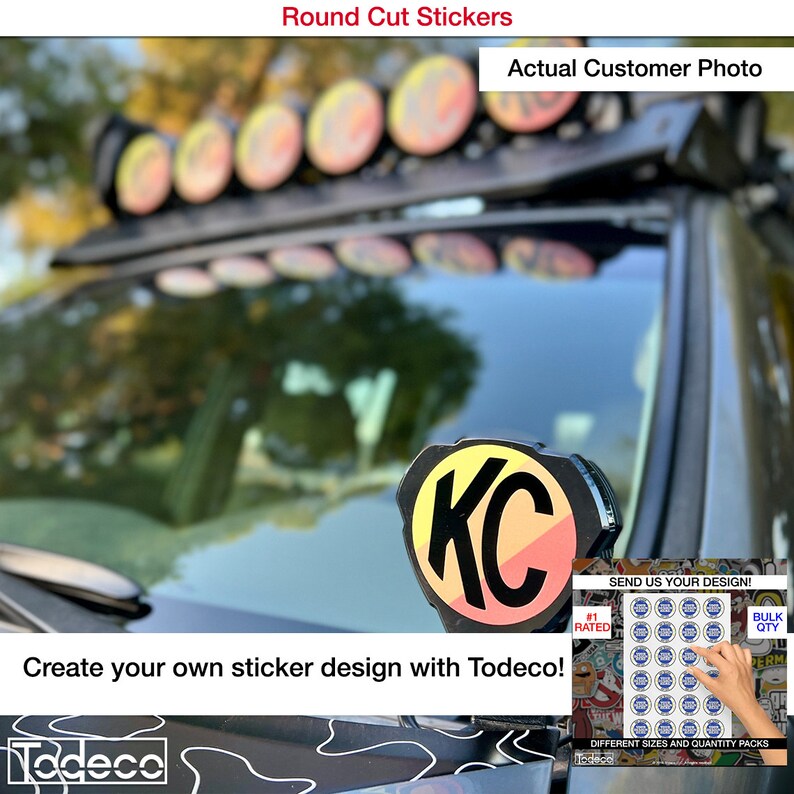 Puede incluir: Un primer plano de una pegatina redonda personalizada con las letras "KC" en negro sobre un fondo amarillo, naranja y rojo. La pegatina est&aacute; en un coche negro con una baca negra. El texto "SEND US YOUR DESIGN!" es visible en la esquina inferior derecha de la imagen.