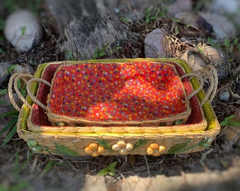 Set of three nesting rattan baskets from the 1970s lined with vintage fabric and decorated with rattan flowers
