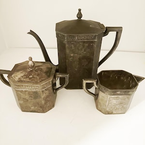Early vintage Dutch teaset featuring a tea pot, creamer and sugar with traditional Dutch motifs such as windmills and rural scenes