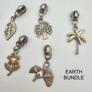 May include: A set of five antique brass zipper pulls featuring nature-inspired designs including a leaf, a tree, a palm tree, a flower with the text you me, and a ginkgo leaf. The text EARTH BUNDLE is printed in the bottom right corner.