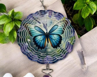 May include: A purple and blue metal wind spinner with a butterfly design. The spinner has a purple bead and a silver chain.