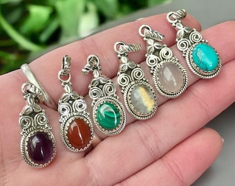 May include: Seven silver pendants with different colored gemstones. The pendants feature intricate silver designs and are perfect for jewelry making.