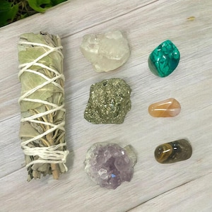 Peut inclure: Un ensemble de sept cristaux et un b&acirc;tonnet de sauge. Les cristaux comprennent du quartz clair, de la pyrite, de la malachite, de la cornaline, de l'am&eacute;thyste et de l'&oelig;il de tigre.