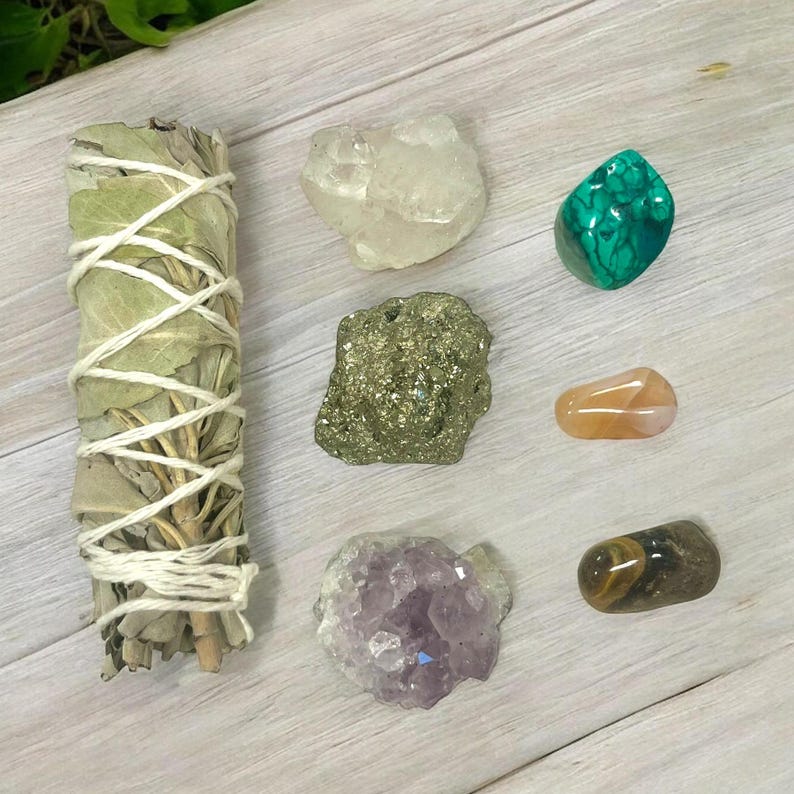 Peut inclure: Un ensemble de sept cristaux et un b&acirc;tonnet de sauge. Les cristaux comprennent du quartz clair, de la pyrite, de la malachite, de la cornaline, de l'am&eacute;thyste et de l'&oelig;il de tigre.